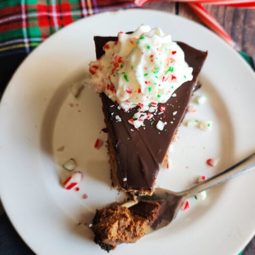 chocolate cheesecake with smooth peppermint mocha ganache, decorated with crushed candy canes, ready to serve.