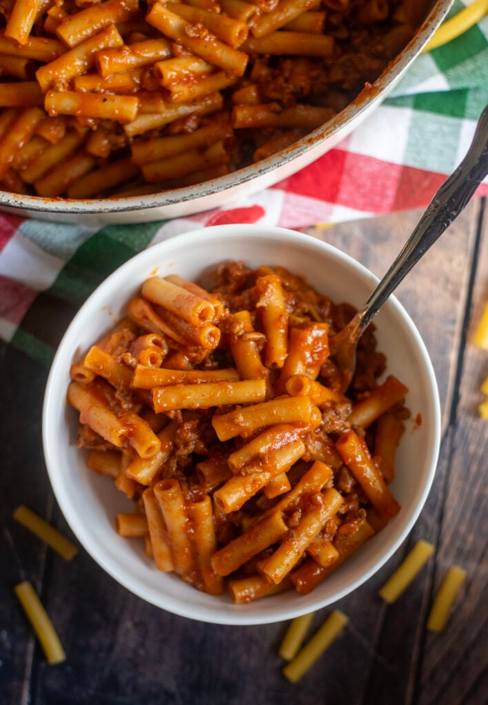 Finished homemade beefaroni in a bowl with creamy tomato sauce and ziti pasta, sprinkled with pepper