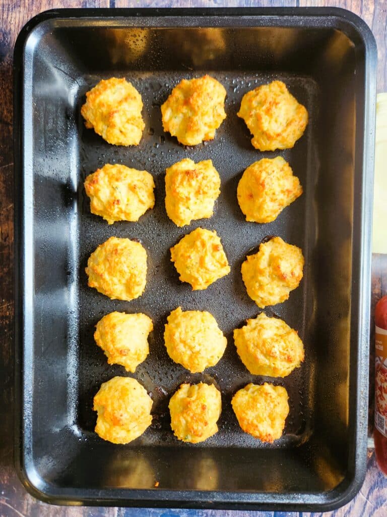 Golden baked chicken meatballs fresh from the oven on a baking tray
